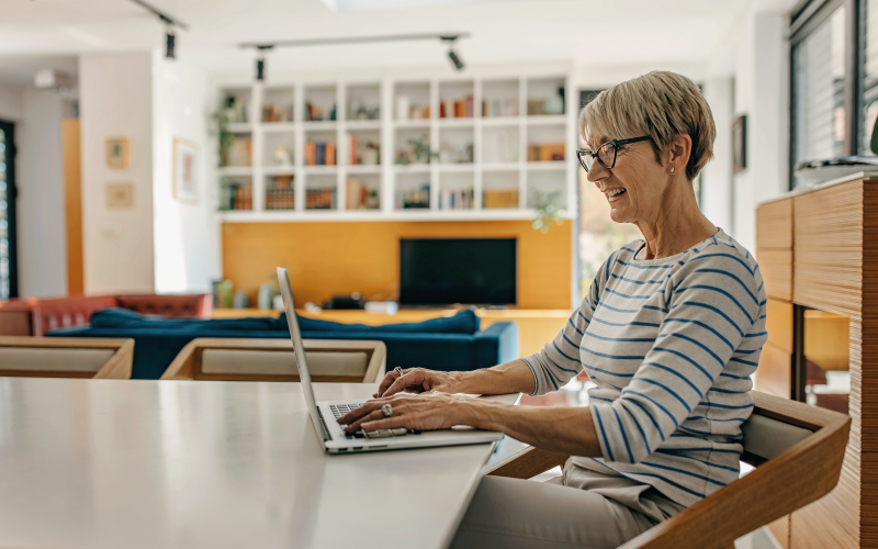 A mature woman using a laptop computer at home.