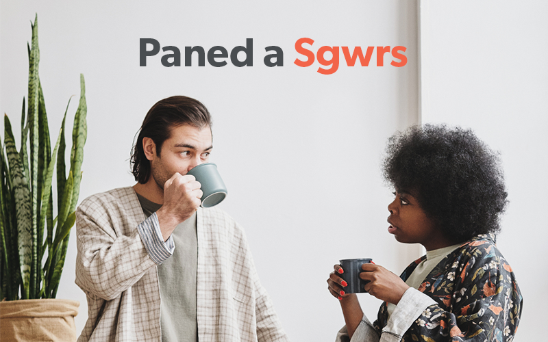 A man and a Woman enjoying a mug of a nice warm beverage near a wall and a green plant. They seem to be in conversation, which is the purpose of the event this picture is promoting. The Words Paned a Sgwrs appear in Audit Wales corporate colours of Dark Grey and Orange