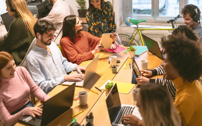 Picture of an office with people working on laptops. 