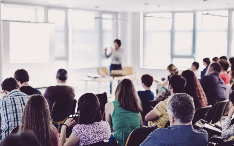 someone presenting to an audience at a conference