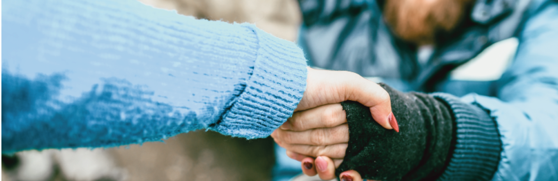 Person sleeping on the street shaking the hand of another person