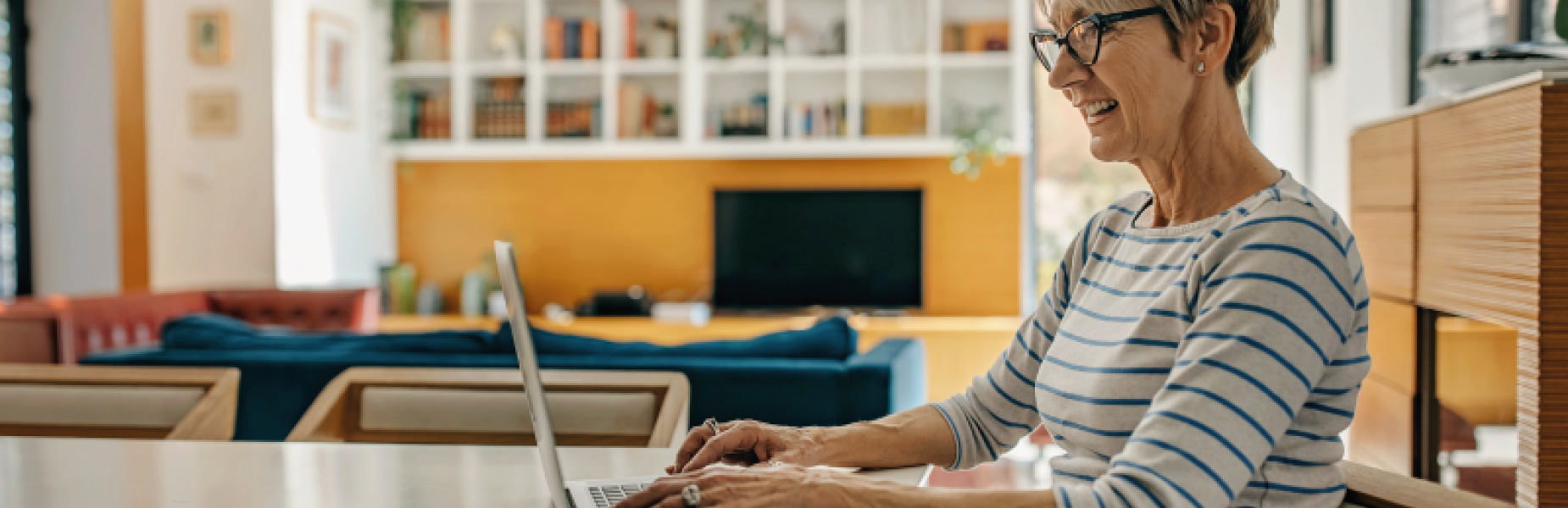 A mature woman using a laptop computer at home.