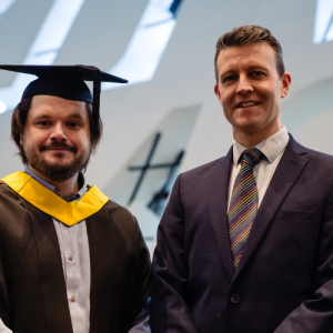 David in graduation clothing stood next to his manager Steve Lisle.